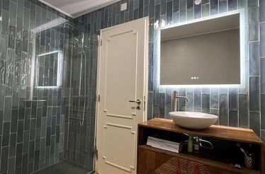 Casa de banho Mudelar: espaço moderno com azulejos cinzentos, espelho iluminado e lavatório elegante