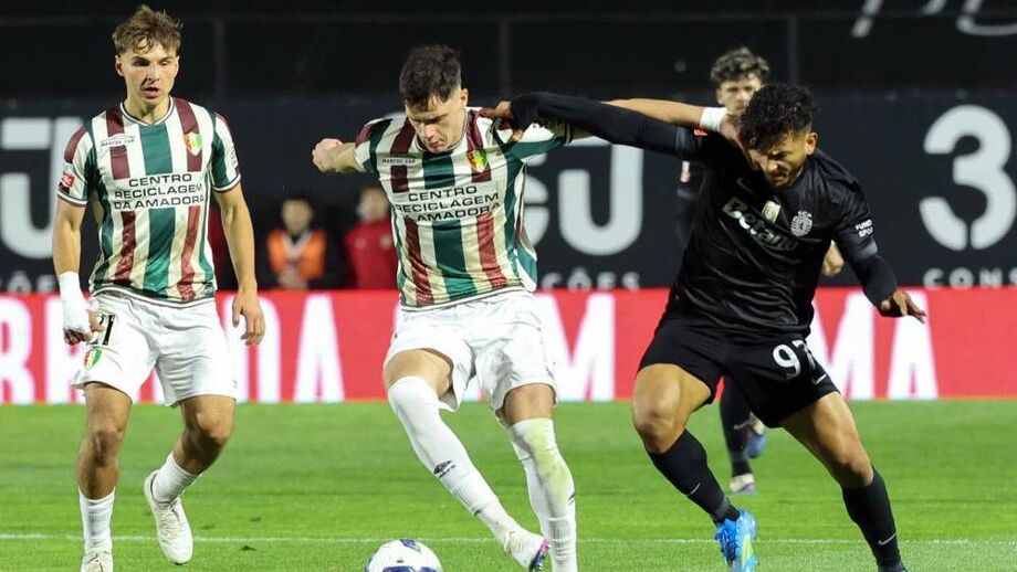 Os jogadores de E. Amadora e Sporting em ação na Reboleira 