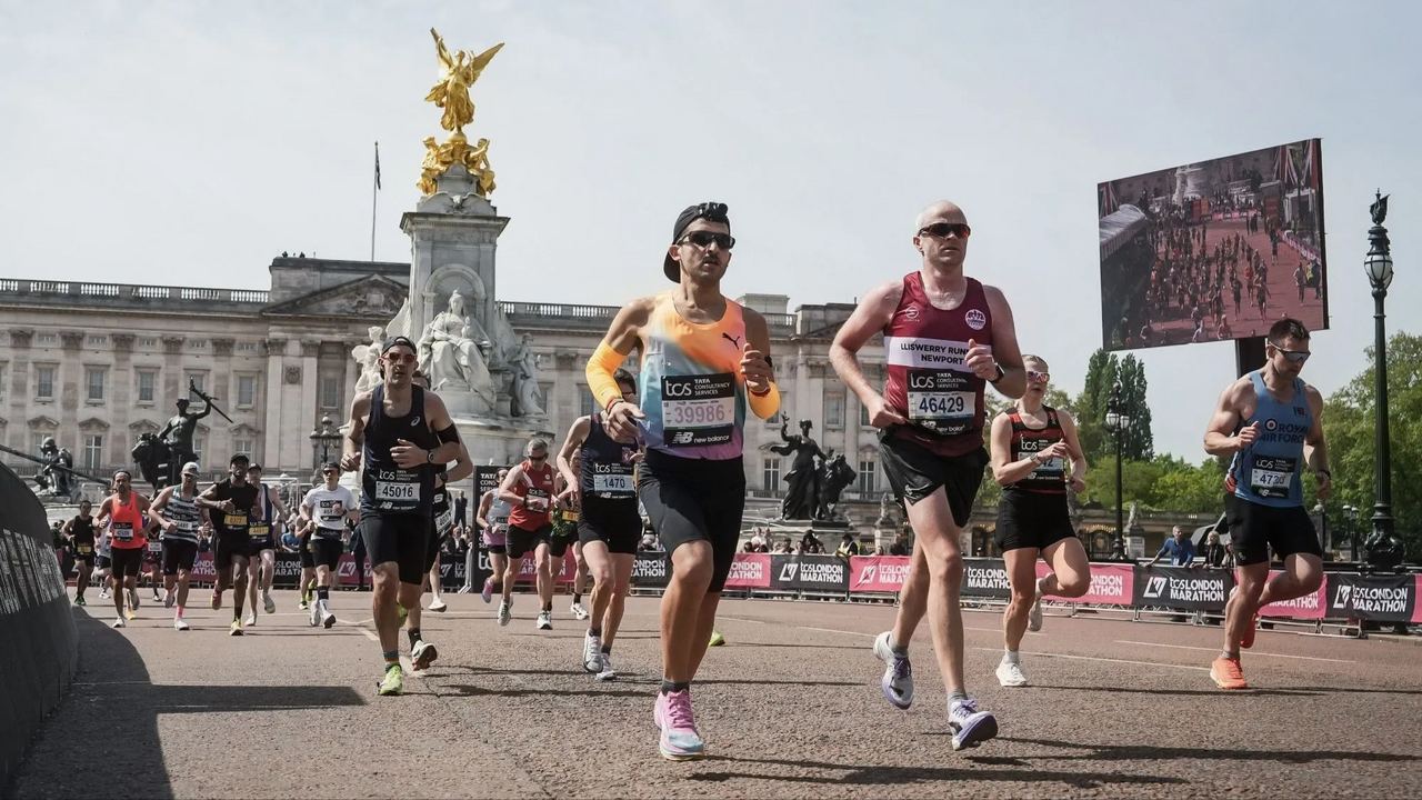 Participantes na Maratona de Londres correm perto do Palácio de Buckingham.

