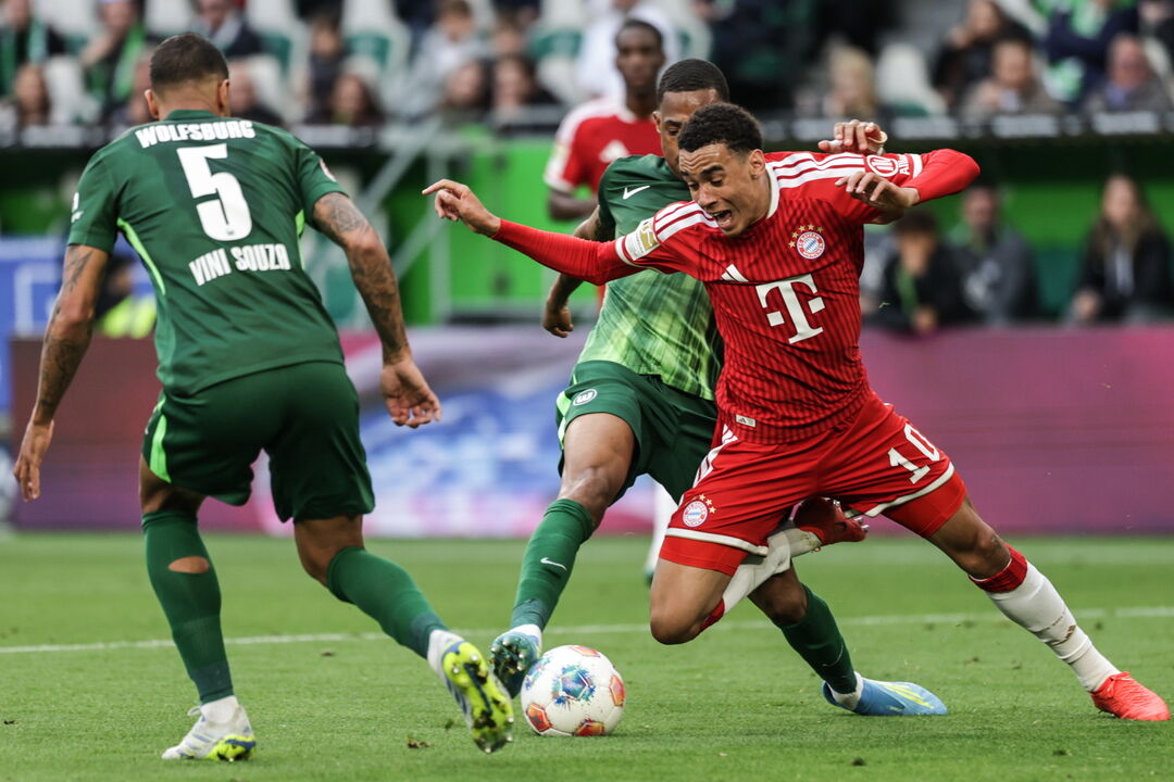 Disputa de bola acesa entre jogadores do Bayern e Wolfsburg na Bundesliga