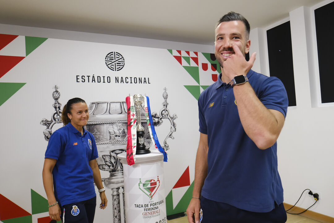 Técnico e jogadora piscam o olho ao troféu