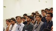 Pessoas assistem a uma apresentação em sala de aula
