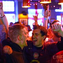 <![CDATA[ À falta de um sofá, fica-se pelo bar: adeptos do Arsenal festejam nos pubs de Londres a conquista da Premier League ]]>