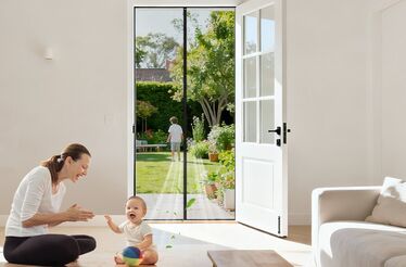 Mãe e bebé brincam perto da porta que dá acesso ao jardim