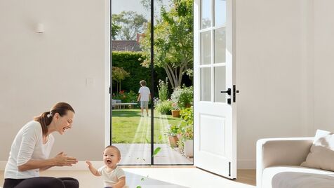 Mãe e bebé brincam perto da porta que dá acesso ao jardim