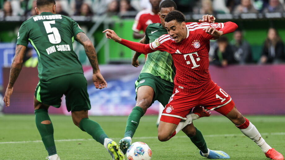 Disputa de bola acesa entre jogadores do Bayern e Wolfsburg na Bundesliga