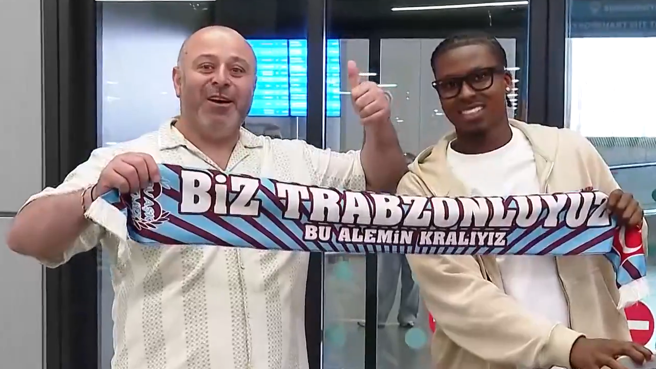 Sidny Lopes Cabral posa com cachecol do Trabzonspor junto de um adepto