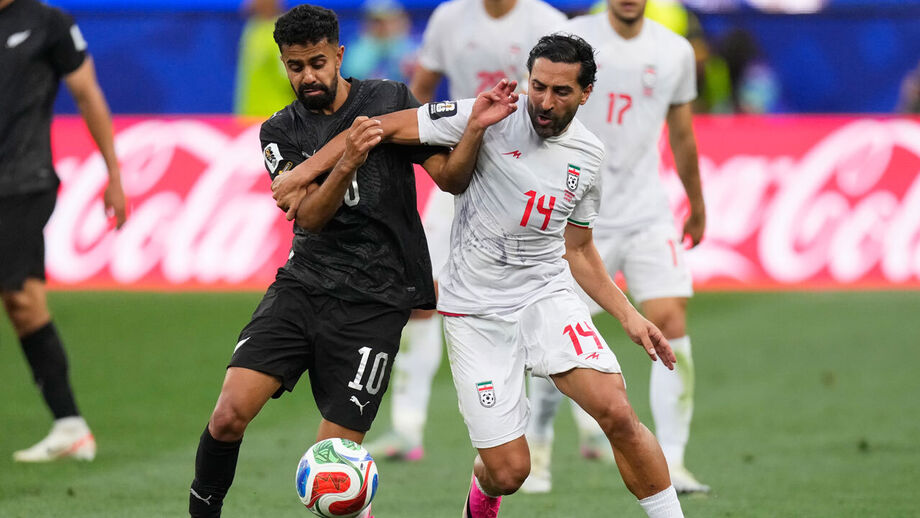 Sarpreet Singh (à esquerda) numa disputa de bola com Saman Ghoddos, da seleção do Irão