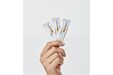 Mão segura 3 ampolas de Heliocare 360º Junior Oral Sticks