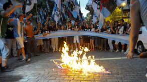 Manifestantes queimam uma bandeira britânica em protesto contra a chegada do Príncipe William às Ilhas Malvinas, no exterior da Embaixada do Reino Unido em Buenos Aires, na Argentina, em 2012