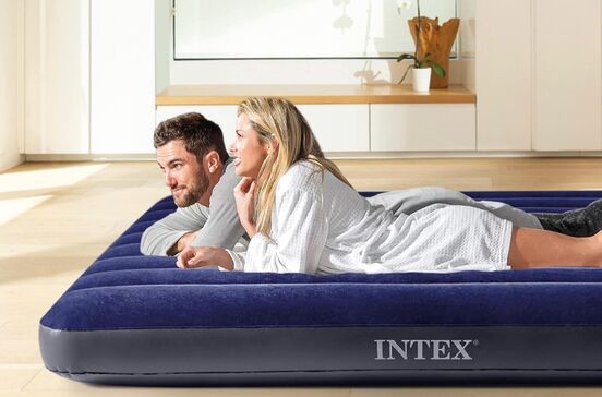 Casal relaxa num colchão insuflável Intex, ideal para visitas e campismo