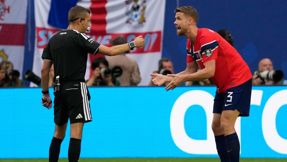 Clément Turpin (à esquerda) e Kristoffer Ajer (à direita) discutem durante o Noruega-Inglaterra no Mundial'2026