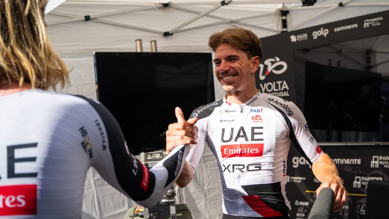 Ciclista da UAE Emirates aperta o polegar a outro ciclista