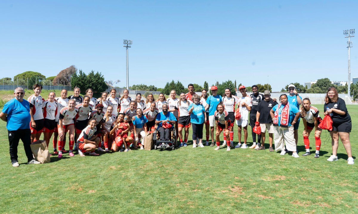 Grupo de rugby posa para fotografia no campo de treino