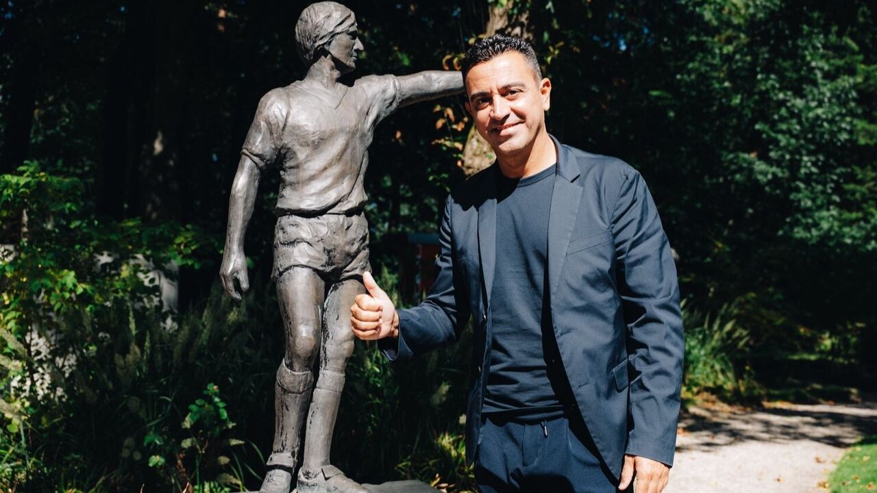 Xavi Hernández, selecionador da Holanda, ao lado da estátua de Johann Cruyff
