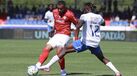 Os jogadores disputam a posse da bola no relvado no