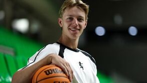 Jogador de basquetebol com uma bola na arena verde