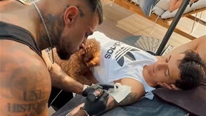 Troféu de campeão nacional tatuado no braço de Kiwior