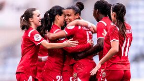 Jogadoras celebram golo em campo durante jogo