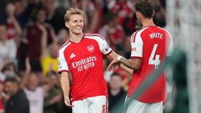 Arsenal's Martin Odegaard, left, smiles after scoring his side's third goal during the English Premier League soccer match between Arsenal
