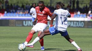 Os jogadores disputam a posse da bola no relvado no