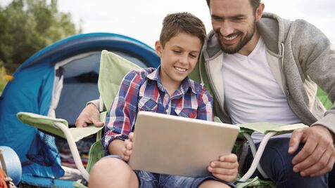 Pai e filho no campismo usam um tablet