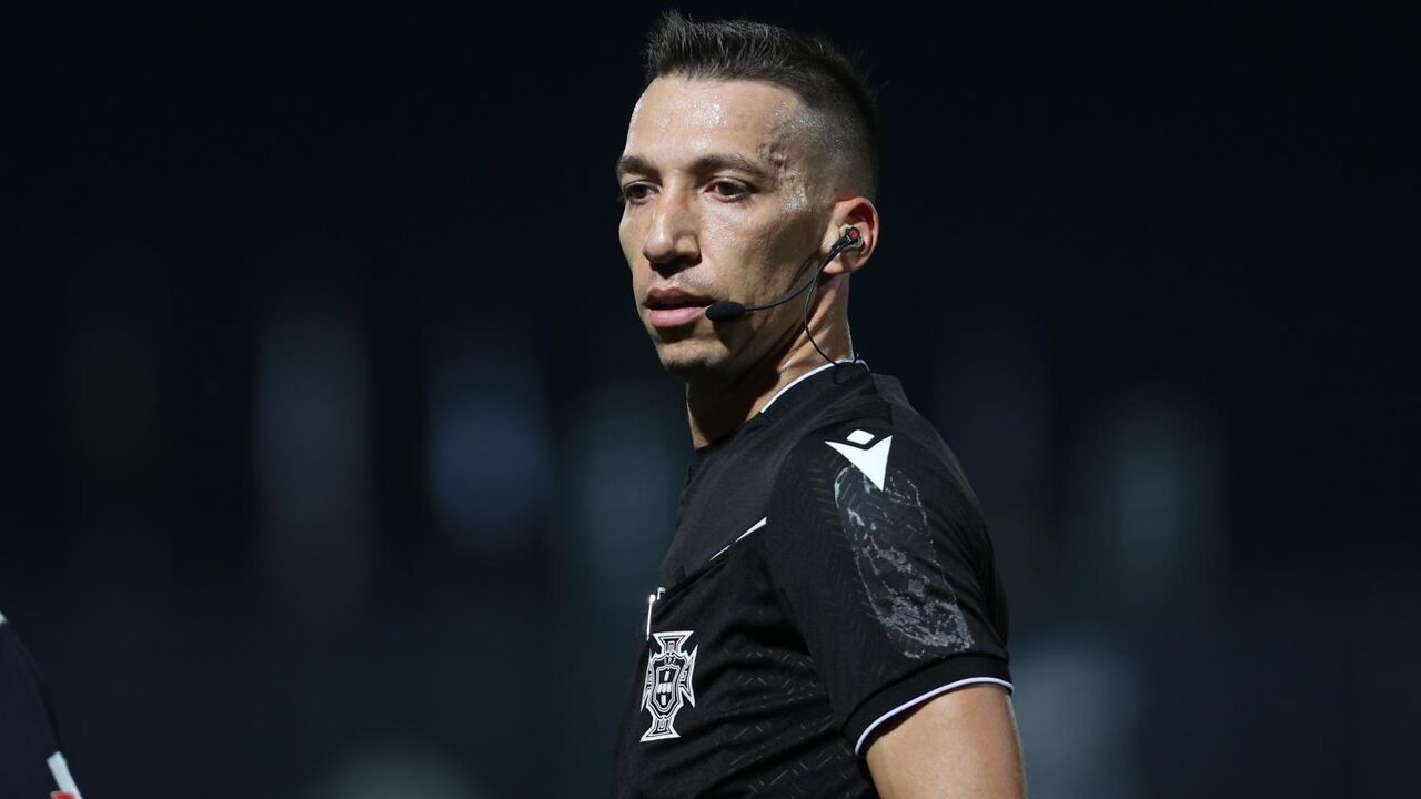 O árbitro em ação no relvado durante o jogo. Costas