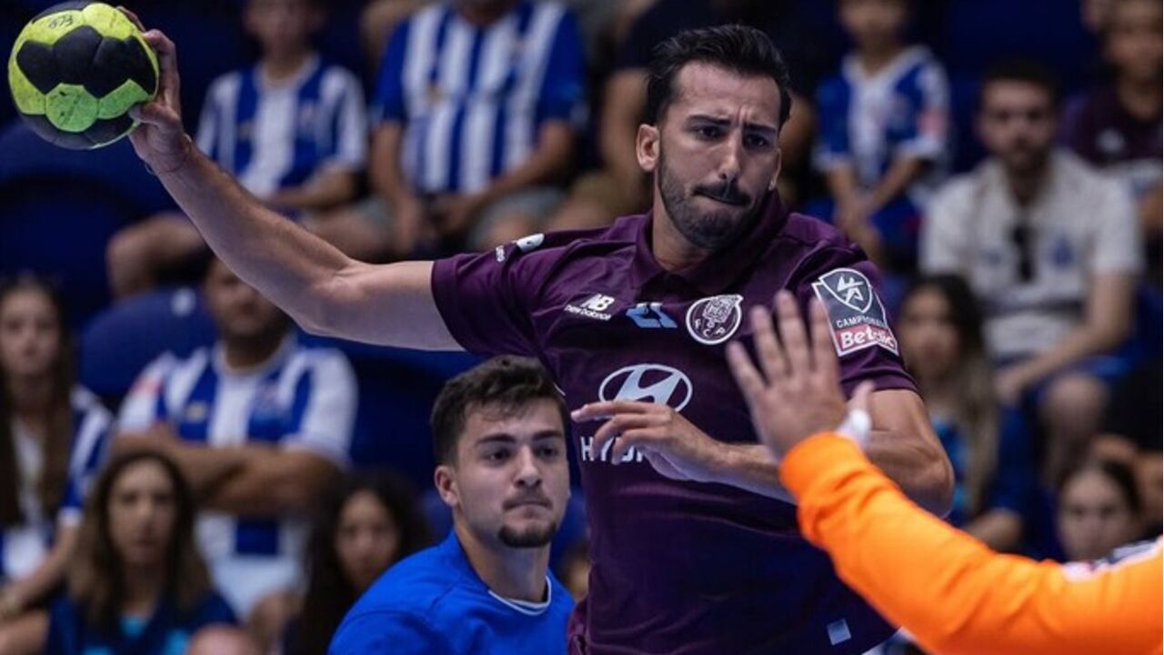 Jogador do FC Porto lança a bola durante jogo de andebol contra o Belenenses