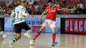 Os jogadores disputam a posse da bola no pavilhão no