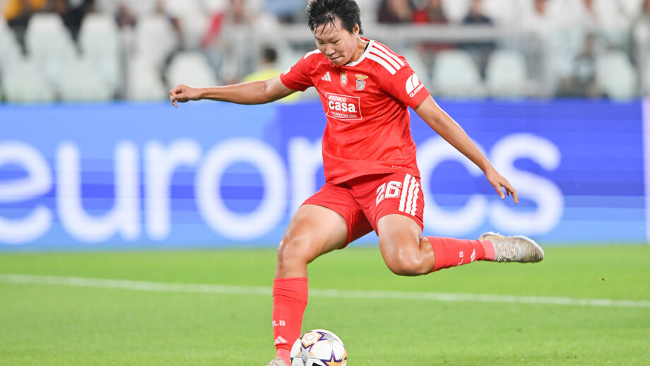 Jogadora do Benfica chuta a bola em campo