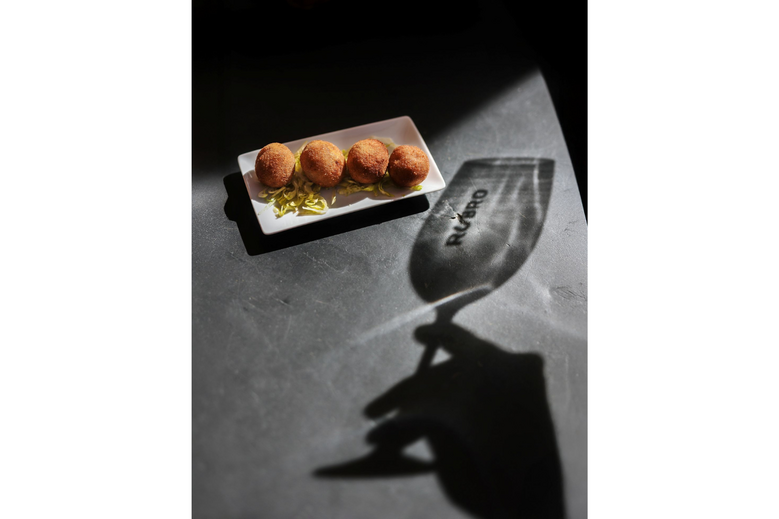 Croquetes de carne sobre uma base de alface e sombra de copo
