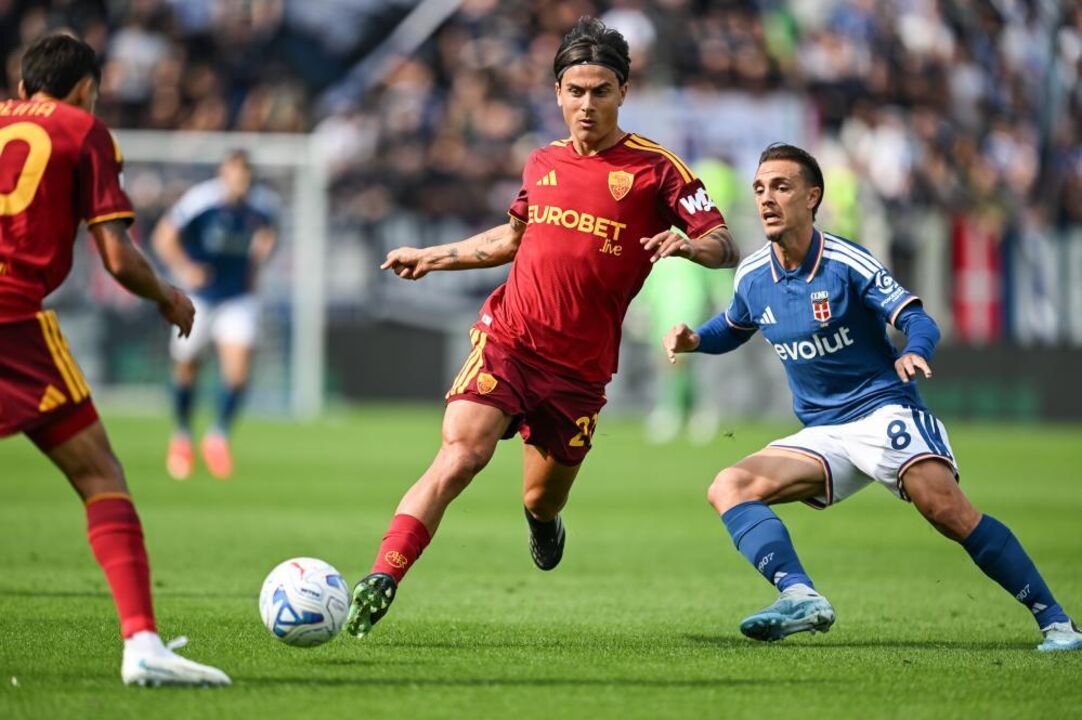 AS Roma's Paulo Dybala, center, vies for the ball with