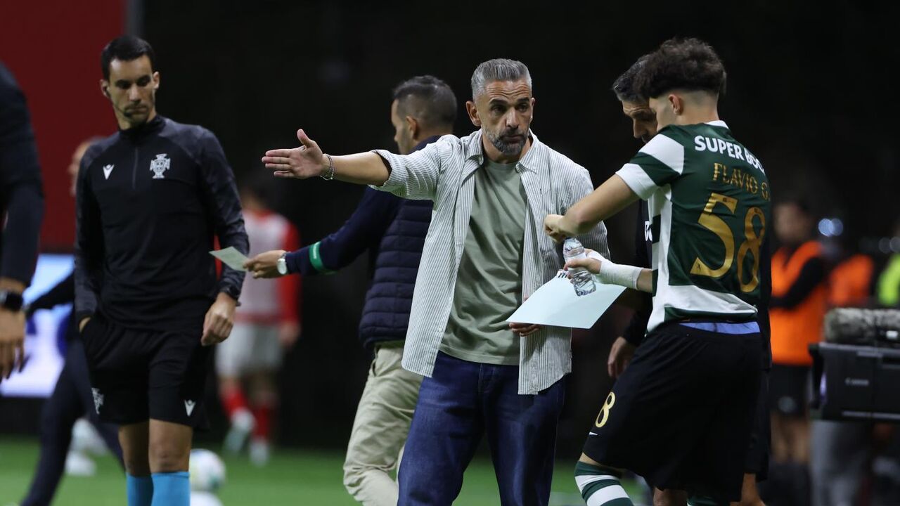 Treinador fala com jogador em campo durante jogo