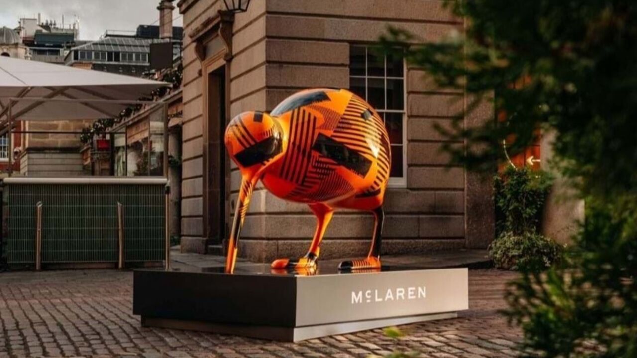 Kiwi McLaren com padrão laranja e preto exposto na rua