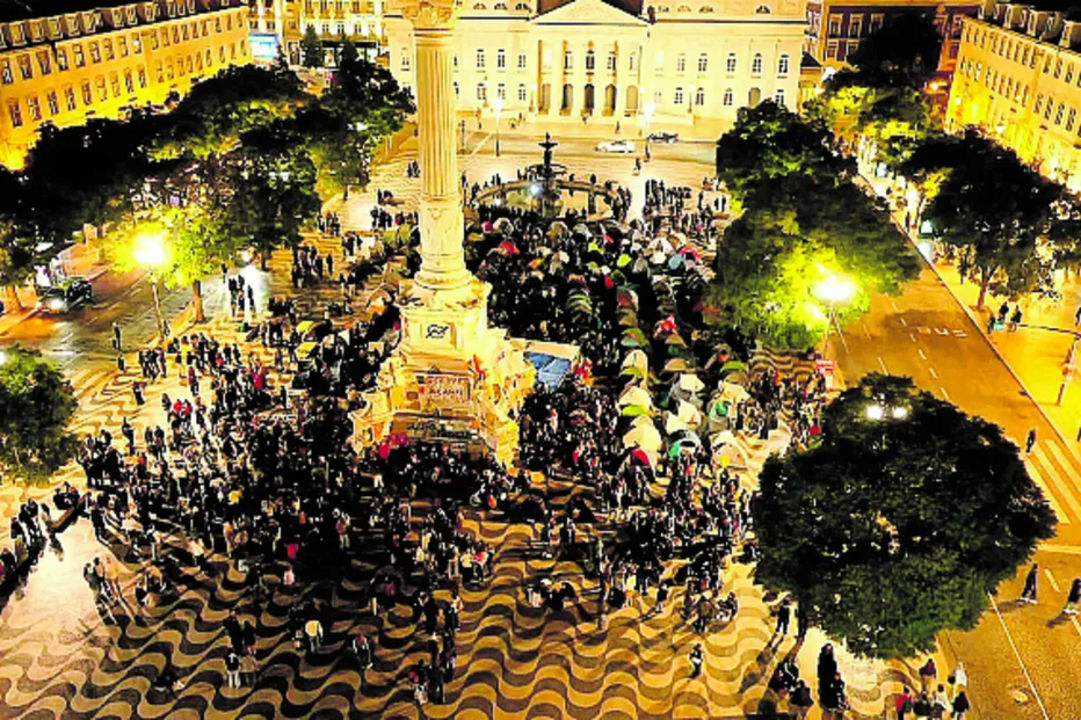 Manifestantes acampam no Rossio, Lisboa, com drones a sobrevoar o local