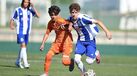 Os jogadores disputam a posse da bola no relvado no