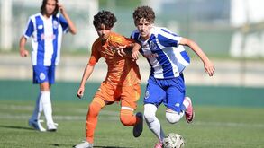 Os jogadores disputam a posse da bola no relvado no