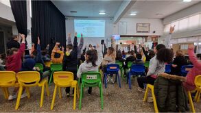 Crianças levantam as mãos em evento escolar sobre bullying e educação