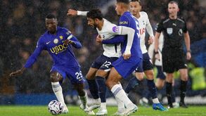 Jogadores disputam a bola em campo chuvoso