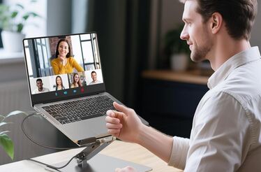 Um homem está numa videochamada com outras pessoas através de um portátil