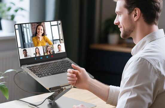 Um homem está numa videochamada com outras pessoas através de um portátil